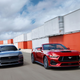 A photo of two 2024 Ford Mustangs driving round a track.